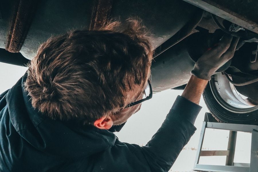 Mechanic working underneath a car on a hoist