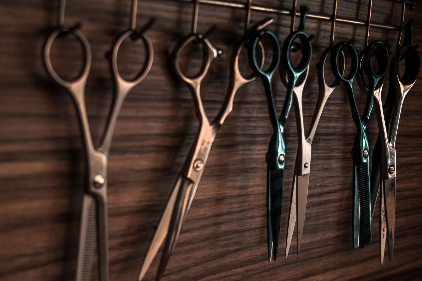 Hairdressing scissors hanging on a wooden wall